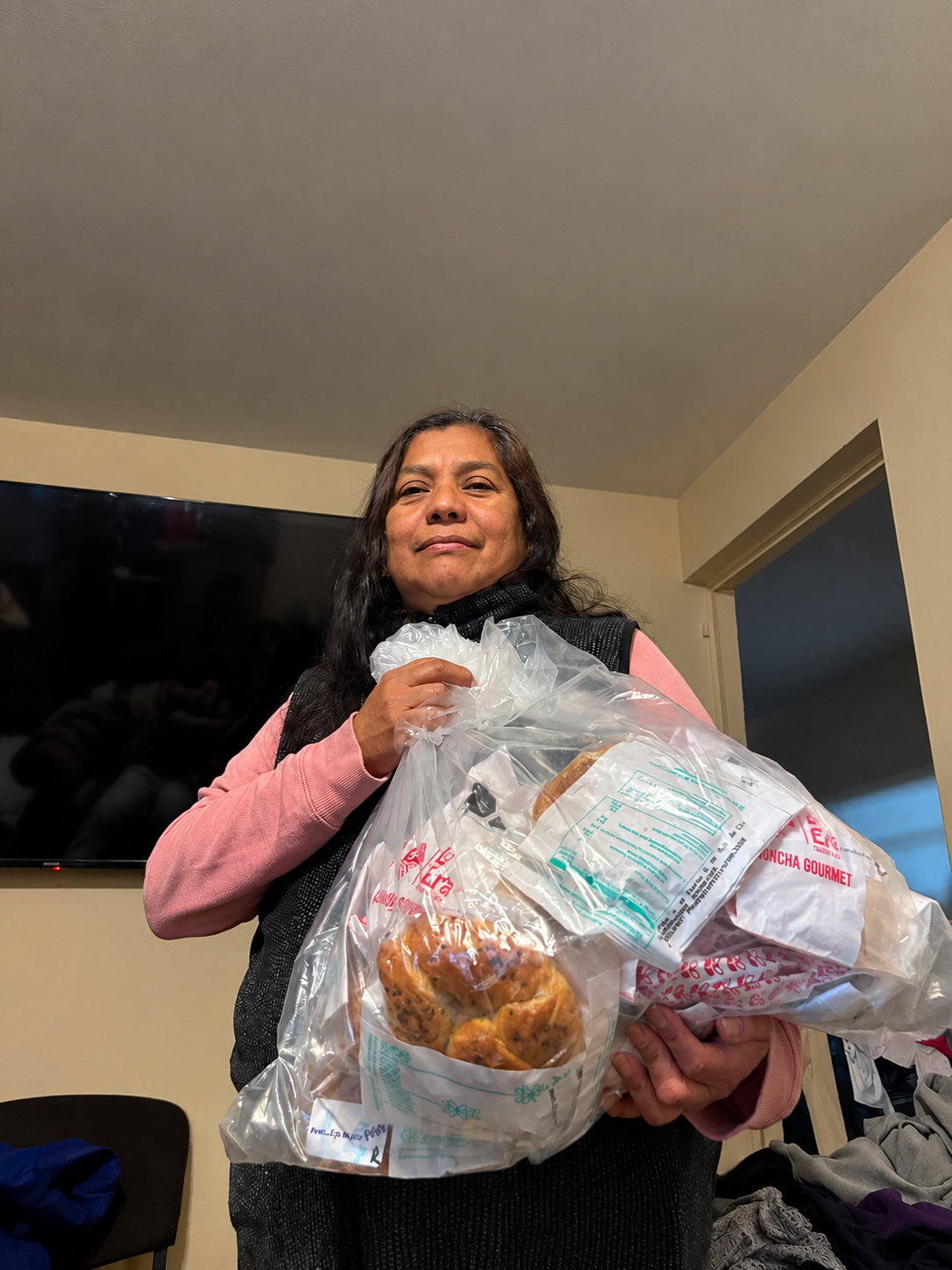 Voluntaria de Fundación Moritas entrega una despensa de pan a una persona de la comunidad