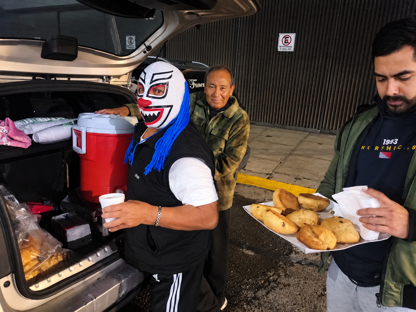 Voluntario de Fundación Moritas reparte pan y bebida caliente por la noche desde una camioneta