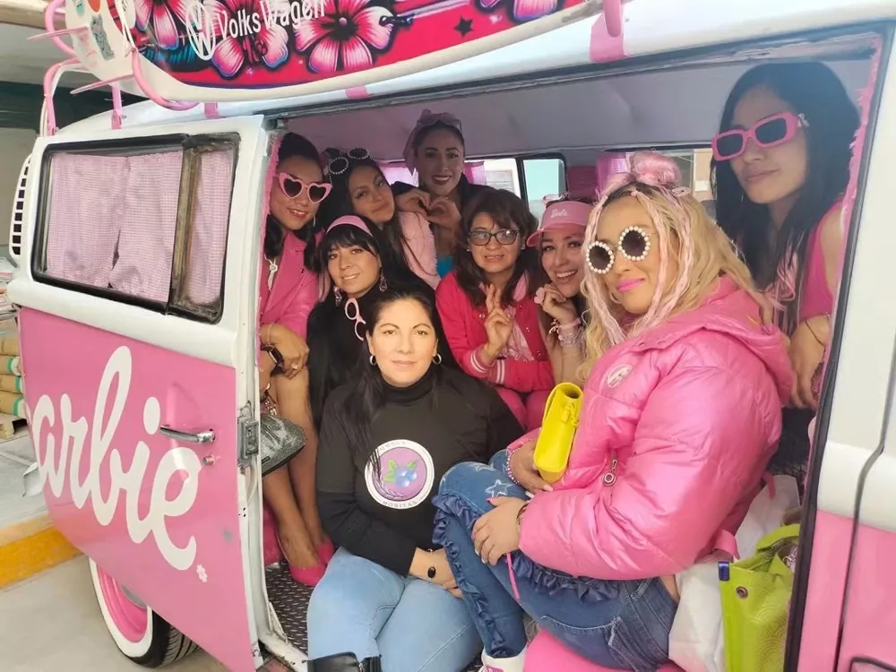 Integrantes y amigas de la fundación a bordo de una camioneta decorada en rosa