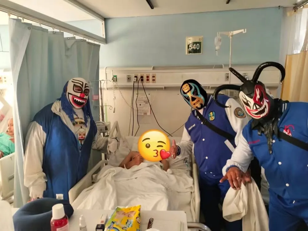 Luchadores enmascarados visitan a una persona en un cuarto de hospital