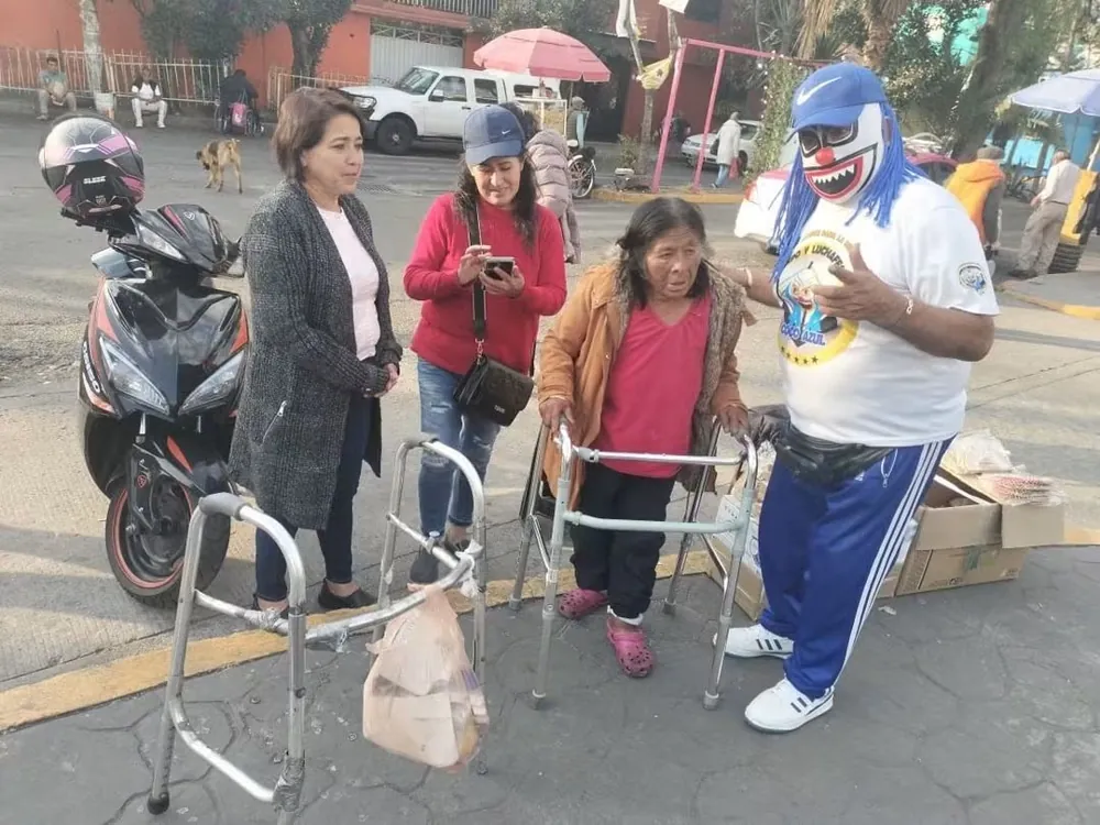 Luchador enmascarado con mujeres que usan andadera en la calle