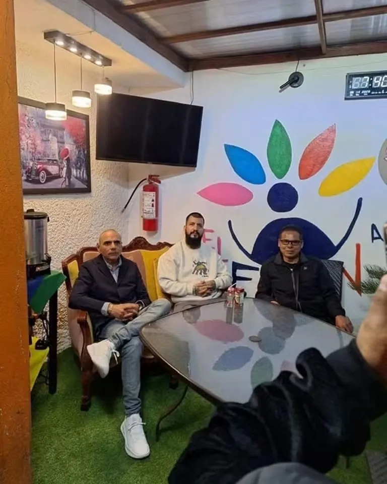Reunión en un local con el logotipo de colores en la pared