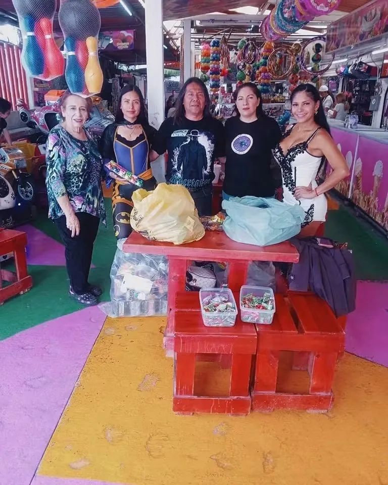 Integrantes de la fundación junto a una mesa con bolsas de juguetes