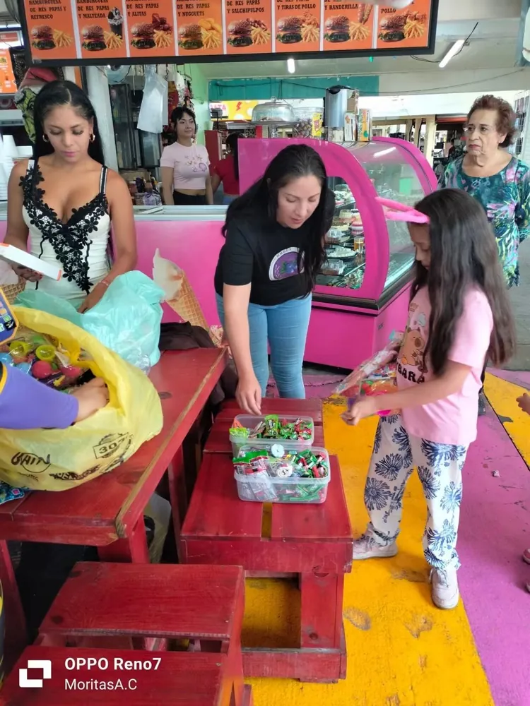 Integrantes de la fundación reparten juguetes a una niña