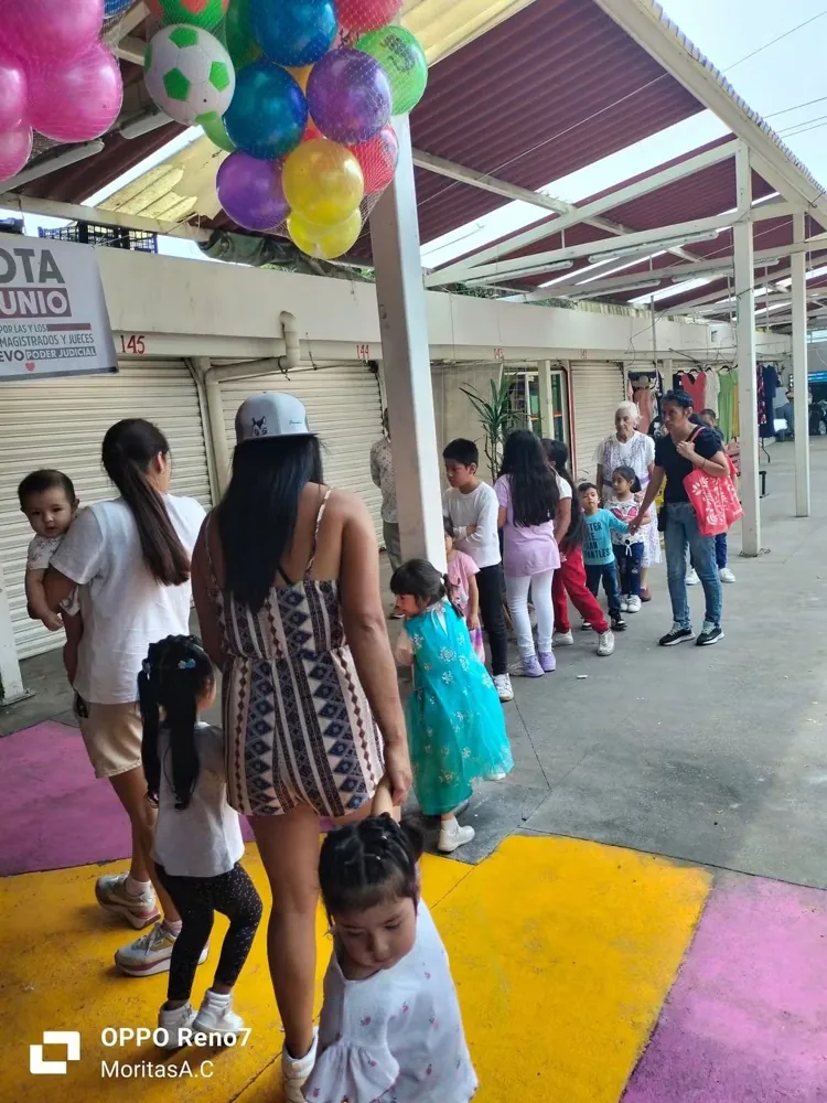 Fila de niñas, niños y familias esperando su entrega