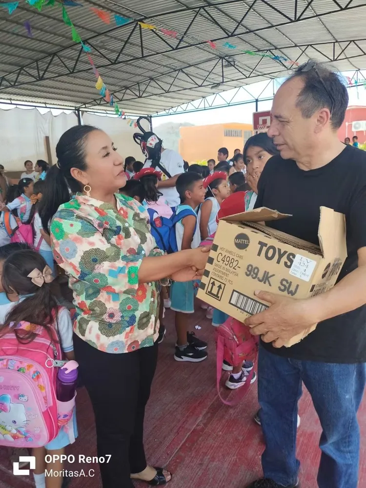 Entrega de una caja de juguetes a estudiantes en una escuela