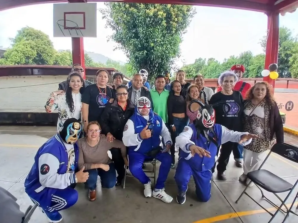 Grupo de la fundación con luchadores en el patio de una escuela