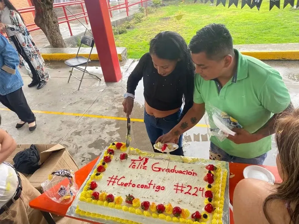 Dos personas parten un pastel durante un convivio de la fundación
