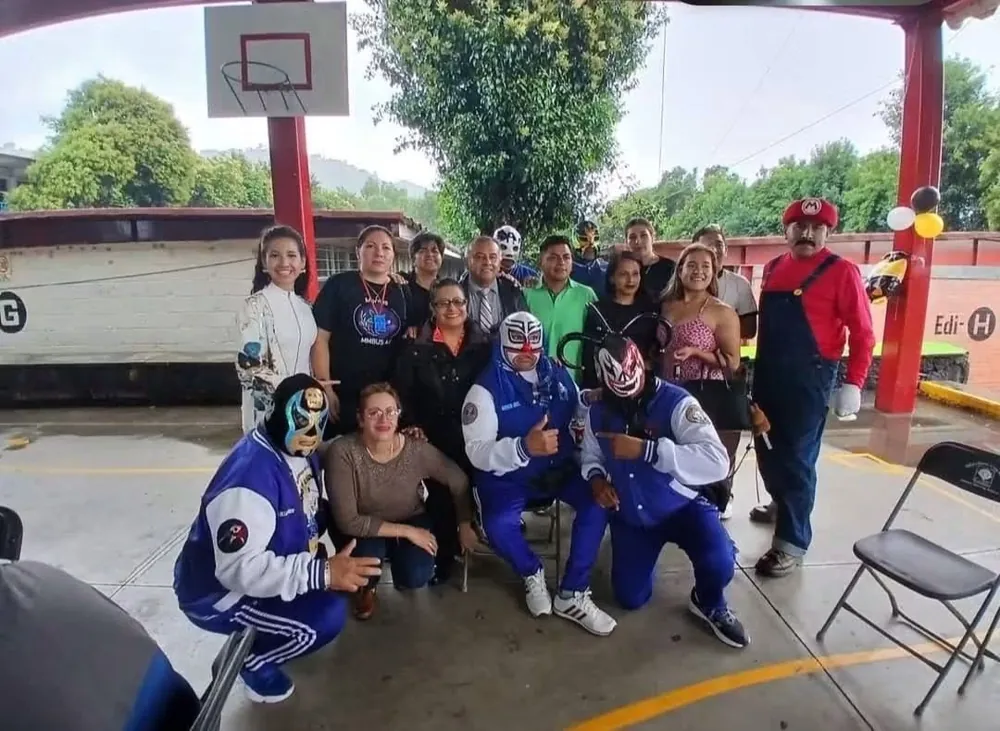 Equipo de la fundación y luchadores en una cancha escolar