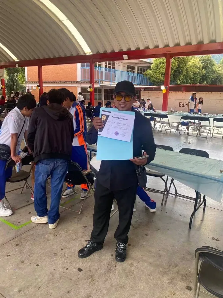 Persona muestra una constancia en un patio techado
