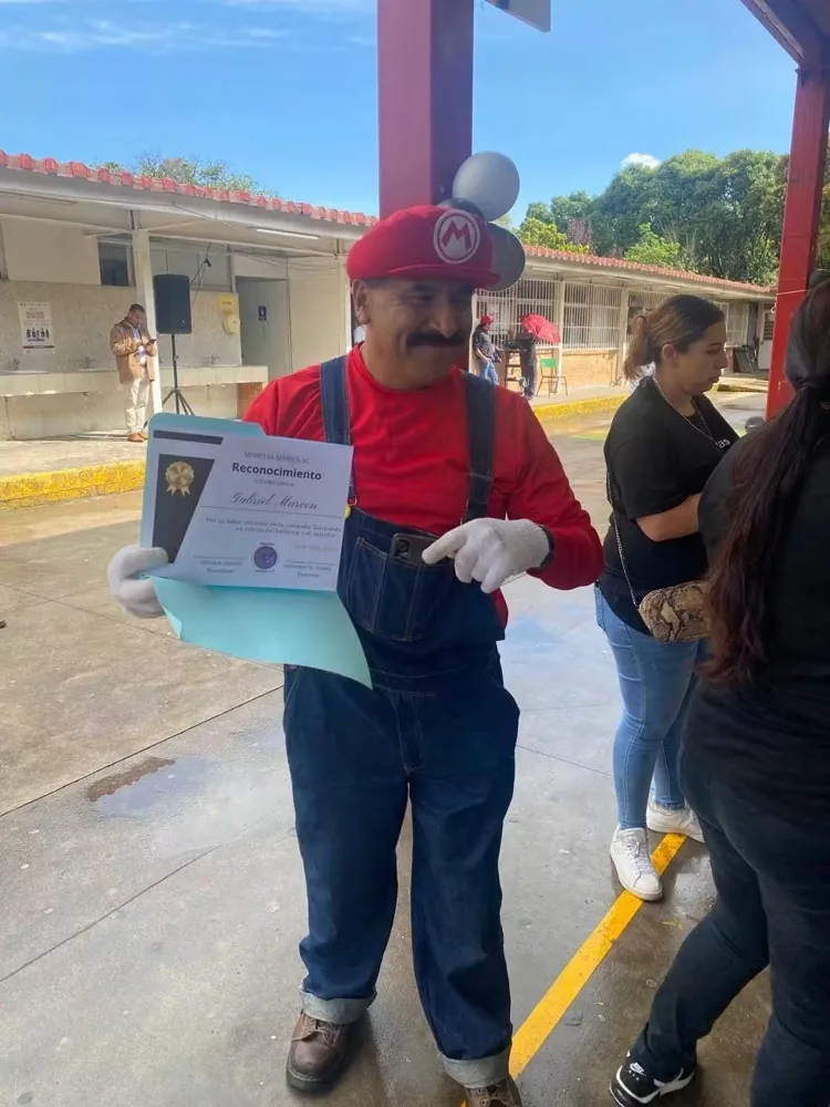 Persona con disfraz de Mario muestra su constancia de reconocimiento