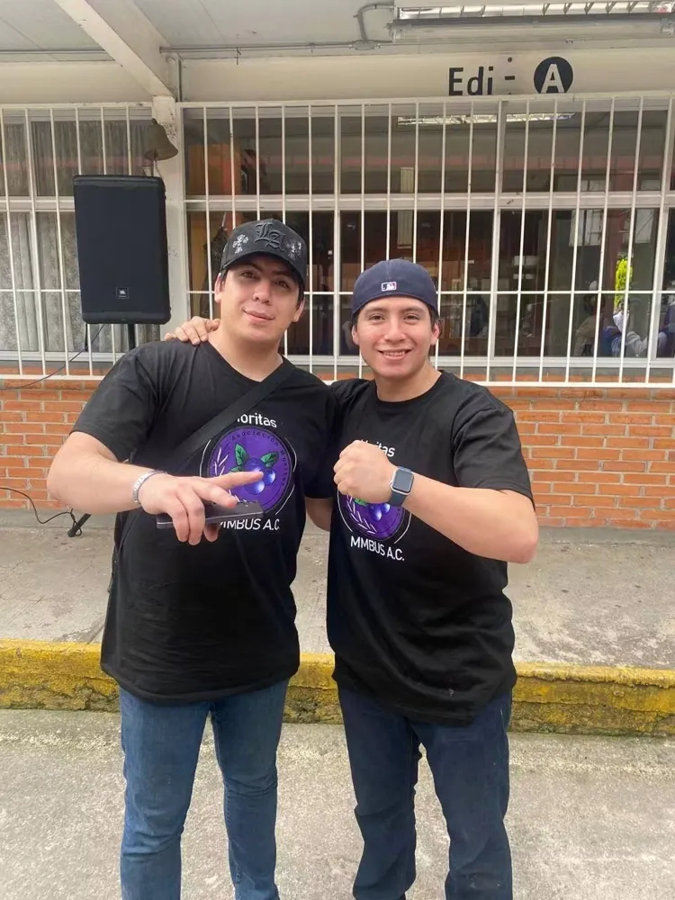 Dos jóvenes del equipo de la fundación posan con playera de Moritas