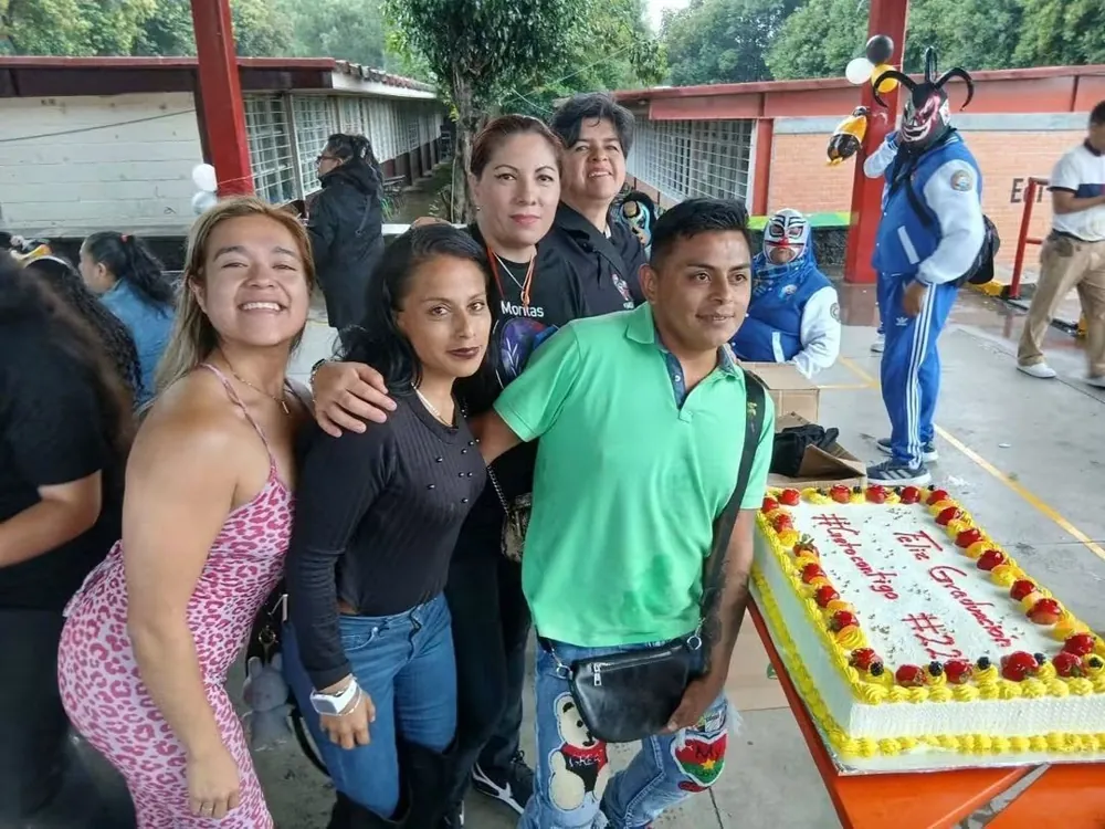 Convivio con pastel, equipo de la fundación y un luchador al fondo